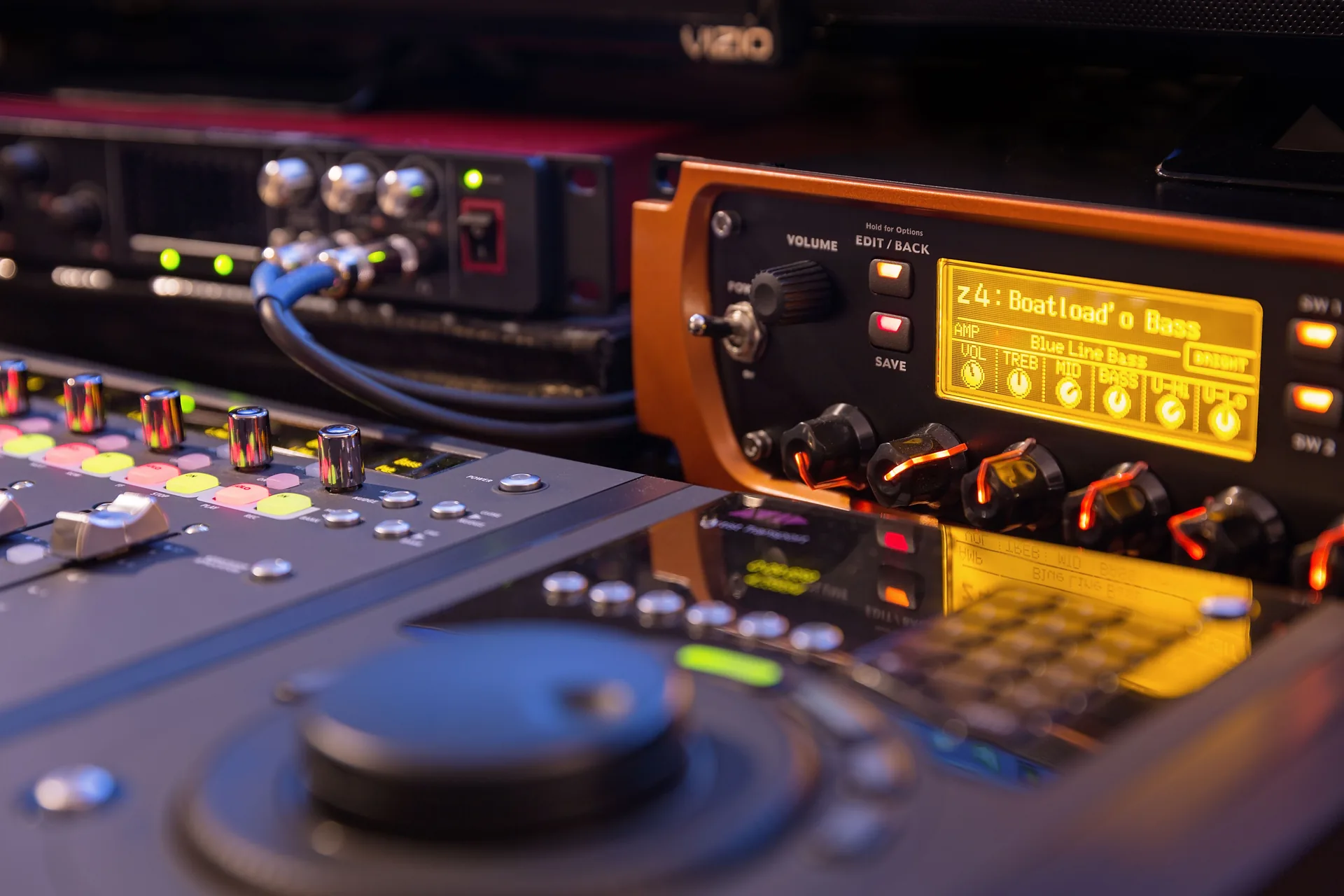 The Avid Eleven Rack’s orange display glowing beside the mixing control surface