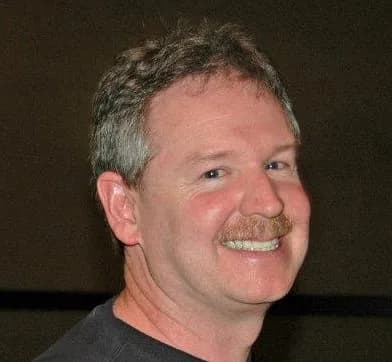 Portrait of Paul Thompson smiling, with a mustache